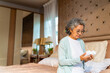 © CandyRetriever  - Asian senior mature woman patient reading medical information label on medicine bottle in bedroom. Elderly retired woman taking medicine pills or vitamins complex supplement for self-care at home.