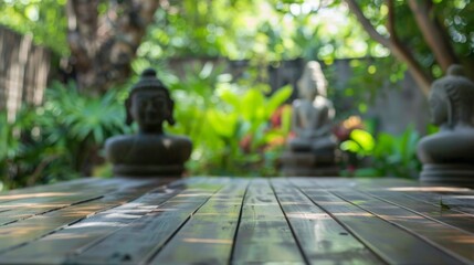 Aufkleber - A wooden table sits in front of two Buddha statues, the lush greenery of a garden visible in the background.