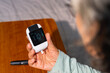 © CandyRetriever  - Asian senior mature woman patient with diabetes using medical device glucometer checking glucose in blood by herself in bedroom at home. Elderly people self-care and daily health check concept.