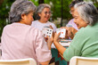 © CandyRetriever  - Group of Happy Asian senior mature women relax and enjoy indoor lifestyle meeting party together at home. Elderly retired woman friends having fun playing card together at home garden in summer day.