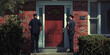 © Lila Patel - Police officers knocking at a front door of a house