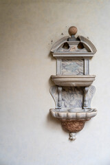 Wall Mural - Vintage baptismal font in marble hanging on wall