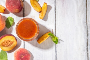 Sticker - Homemade sweet sour peach chutney jam preserves with spices and raisins, in small jar, with fresh ripe peaches on white wooden table