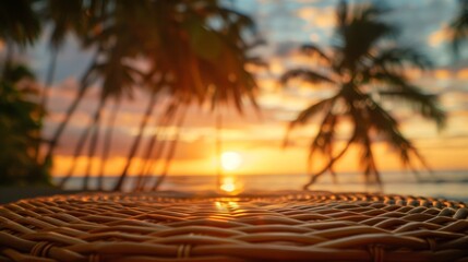 Poster - A close-up of a wicker table with a blurry sunset and palm trees in the background.
