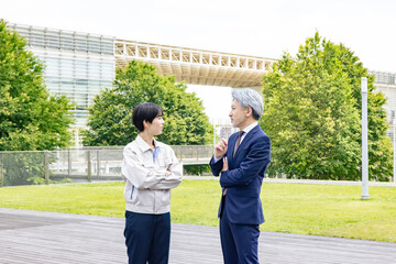 Poster - 屋外で会話するビジネスマンとエンジニア