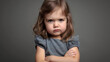 © Maksym - Angry little girl with crossed arms, glaring at the camera with an unhappy expression. Mad female kid, studio shot, frustrated and annoyed toddler child emotion