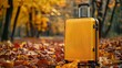 © Kateryna Kordubailo - modern yellow suitcase on the faling autumn leaves background, travel concept