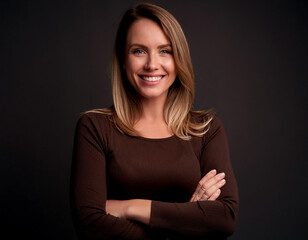 Canvas Print - Beautiful woman smiling with crossed arms in studio shot corporate dark black background