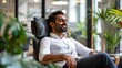 © Matthew - Man relaxing in a modern office chair with plants around