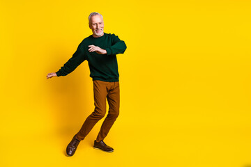 Poster - Full body photo of handsome retired man dancing discotheque wear trendy green outfit isolated on yellow color background