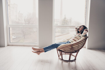 Poster - Photo portrait of attractive young woman sit armchair hands behind head dressed casual clothes cozy day light home interior living room