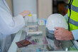 © ultramansk - A pharmacist prepares medicine for a construction worker on the counter of a pharmacy.