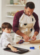 © SunriseDon/peopleimages.com - Baking, dad and child with cookies, learning and support with rolling and chef costume together. Youth, family kitchen and food with ingredients for dessert with dough and bonding in home with love
