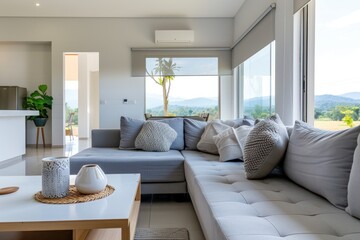 Modern living room with elegant grey couches, expansive window offering stunning views, inviting atmosphere perfect for relaxation or entertaining guests, ample space for personal touch