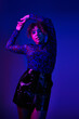 © LIGHTFIELD STUDIOS - Beautiful African American woman striking a pose in vibrant black and purple attire.