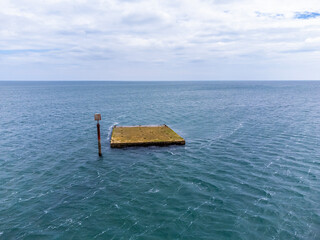 Wall Mural - A view of a top of a Mulberry Harbour wreck at Pagham, Sussex in summertime