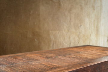 dark wooden table top with empty copy space and gold structured textured wall backround.