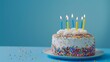 © Ondrej - Birthday cake with colorful sprinkles and candles on a blue background.