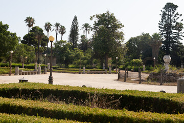 Poster - A serene garden with a stone fountain and lampposts