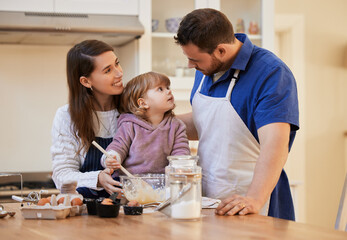 Wall Mural - Cupcakes, baking and parents with child in kitchen for bonding, learning chef skills and fun together. Family, home and mom, dad and girl help with ingredients for cake, dessert and sweet treats