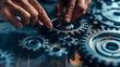© Erika - hombre manipulando unos engranajes haciendo que los engranes se unan tecnica y tecnologia ingenieria industrial trabajo en equipo union y fuerza