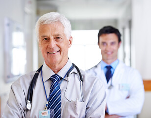 Poster - Portrait, doctor and mature man with smile, arms crossed and leadership in hospital, proud and expert. Clinic, medical professional and confidence of people, healthcare and advice with help