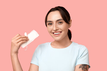 Canvas Print - Beautiful young woman with menstrual pad and tampon on pink background