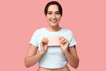 Poster - Beautiful young woman with menstrual pad on pink background