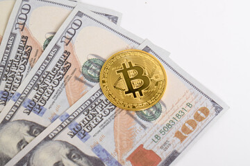 Golden symbolic coin Bitcoin on banknotes of one hundred dollars. Isolated background. Exchange bitcoin cash for a dollars. Cryptocurrency on US dollar bills. Savings, investments concept