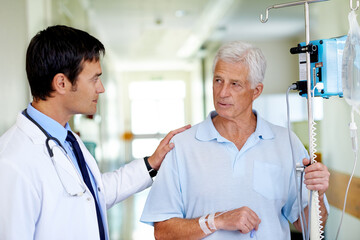 Canvas Print - Hospital, talking and doctor with old man, walking and elderly person with serious for medical appointment. Clinic, IV drip and nutrition for wellness, hydration and listen for healthcare and work