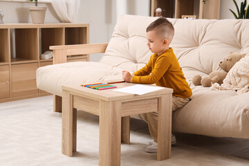 Wall Mural - Cute little boy drawing with felt-tip pens on table at home