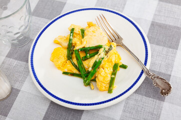 Wall Mural - Tasty wholesome homemade omelette filled with chicken breast and tender green asparagus, served on plate for light balanced dinner