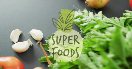 Poster - Super foods text over fresh vegetables including garlic, onion, and leafy greens image