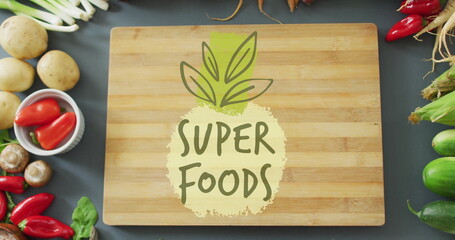 Wall Mural - Super Foods text image over wooden cutting board surrounded by fresh vegetables