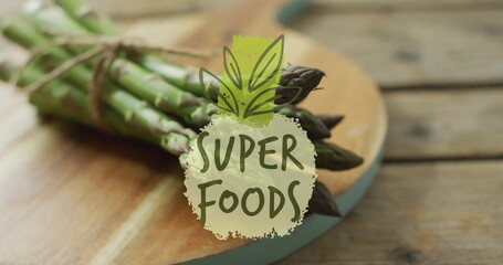 Wall Mural - Superfoods text image over fresh asparagus on wooden cutting board