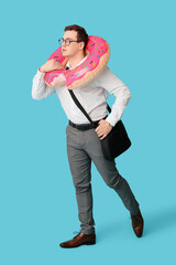 Wall Mural - Office worker with inflatable ring in shape of donut dreaming about vacation on blue background