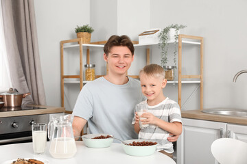 Poster - Happy father and his little son eating cornflakes with milk on breakfast at home