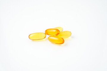 Pile of yellow softgel medical pills, supplement vitamin, isolated over the white background