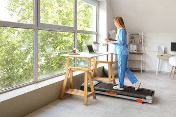 Sticker - Female doctor with clipboard video chatting on treadmill in clinic