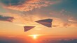 © Artyom - Two paper planes flying through beautiful sunset sky