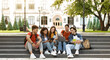 © Prostock-studio - Group Of Students With Digital Tablet And Laptop Study Together Outdoors, Happy Multiethnic Young Friends Sitting On Stairs Near University Building, Using Modern Gadgets For Education, Copy Space