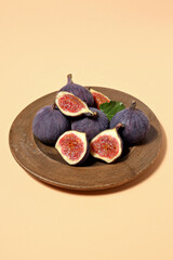 Wall Mural - Fresh ripe figs in a wooden bowl on a light background