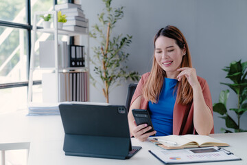 Confident happy young female, business woman leader, professional Asian business woman company manager working on laptop in office sitting at work desk looking at camera, portrait.