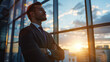 © EmmaStock - A man in a suit is standing in front of a window, looking out at the sunset