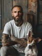 © K silver - A man with a beard and tattoos sits with his arms crossed in front of a dog