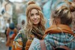 © DKPhoto - A smiling young woman, bundled up warmly for winter, chats with a friend outdoors, showcasing the joy and companionship of wintertime adventures in a colorful urban setting.