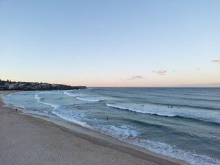 Wall Mural - Aerial drone view sun setting over the beach with silhouettes of people and surfers 