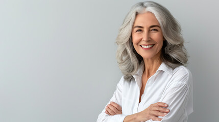 Poster - Handsome woman 50s mid age beautiful physically fit well groomed senior model grey hair stylish smiling Healthy face skin care skincare hair care fitness dental off center copy space gray background