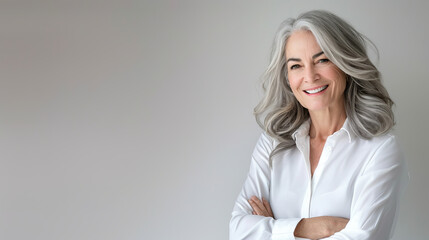 Wall Mural - Handsome woman 50s mid age beautiful physically fit well groomed senior model grey hair stylish smiling Healthy face skin care skincare hair care fitness dental off center copy space gray background