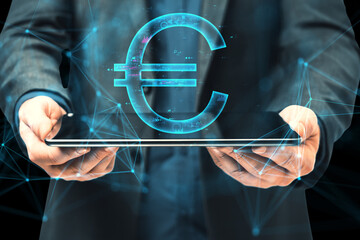 Wall Mural - Close up of male hands using tablet with digital euro sign on blurry background. Digital banking, technology and cryptocurrency concept.